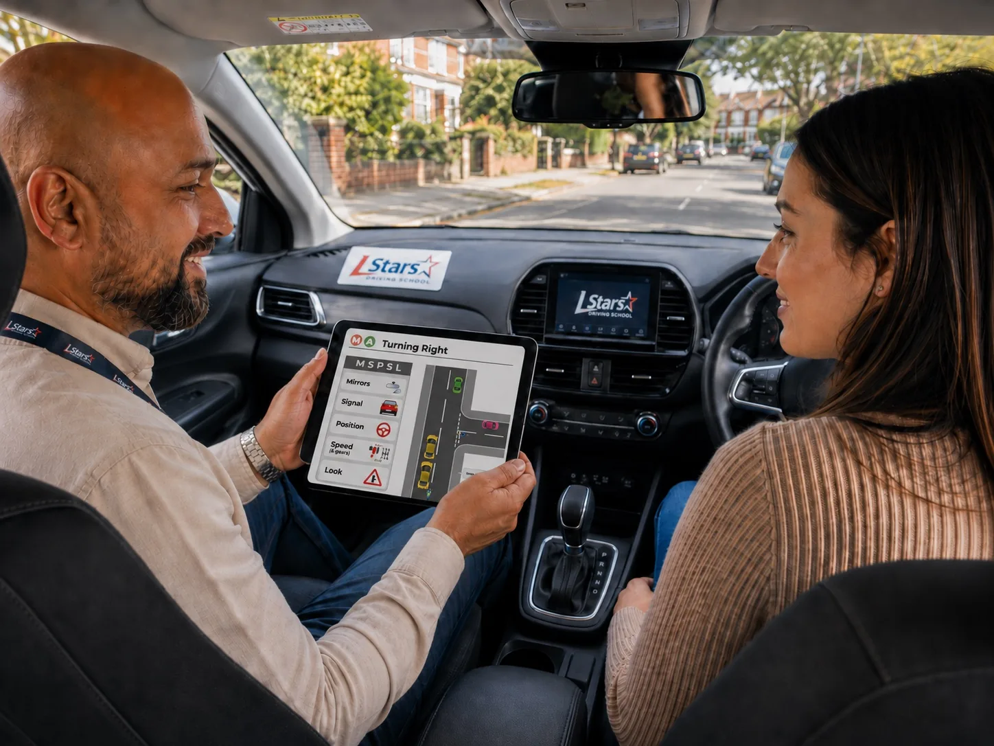 L Stars instructor using an iPad teaching aid with a learner in a right-hand-drive car